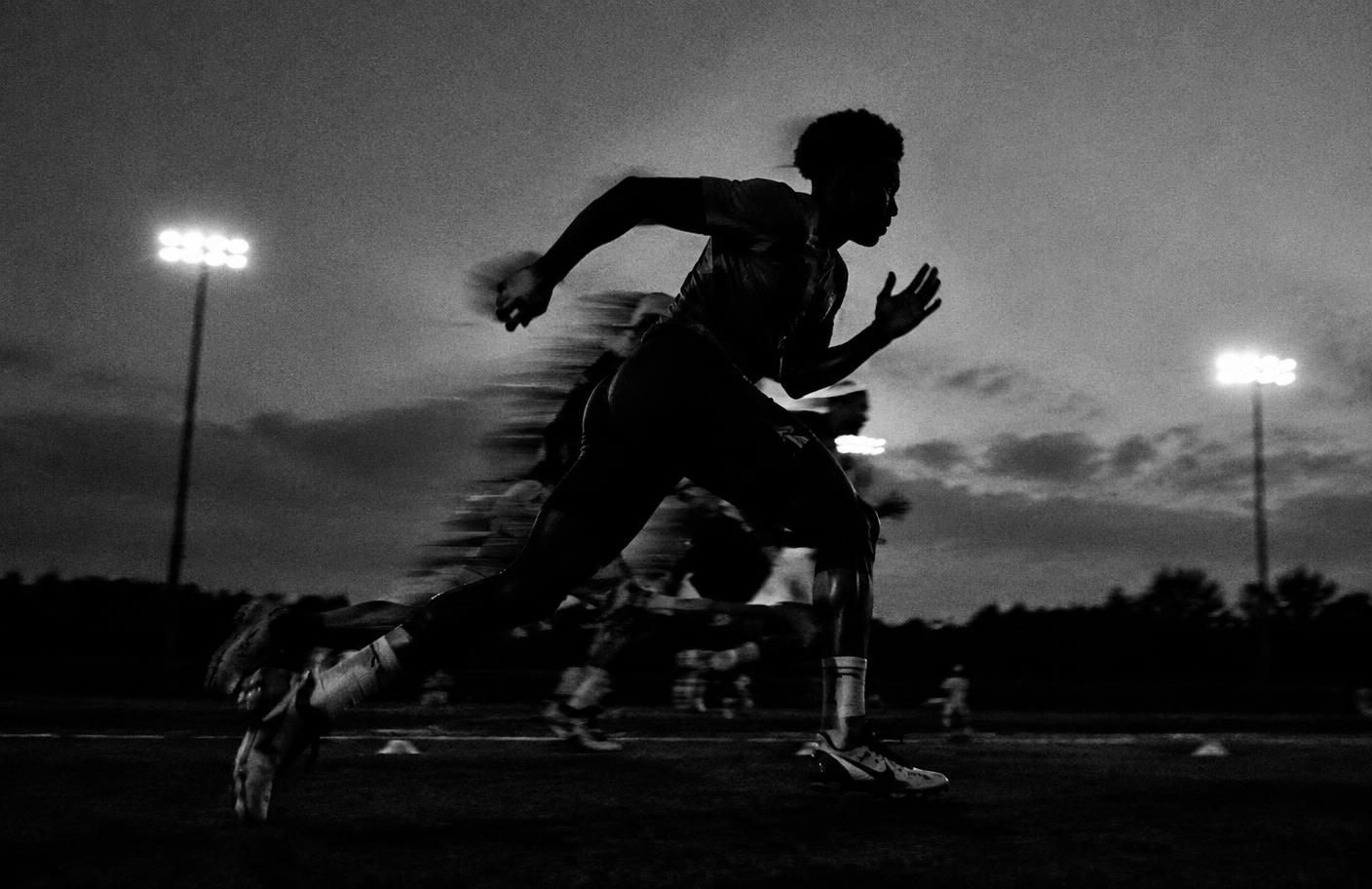 Footballer sprinting through a floodlit training session, motion blur